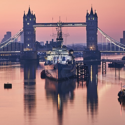 Skyline of London. Tower Bridge against cityscape with skyscrapes at dawn.