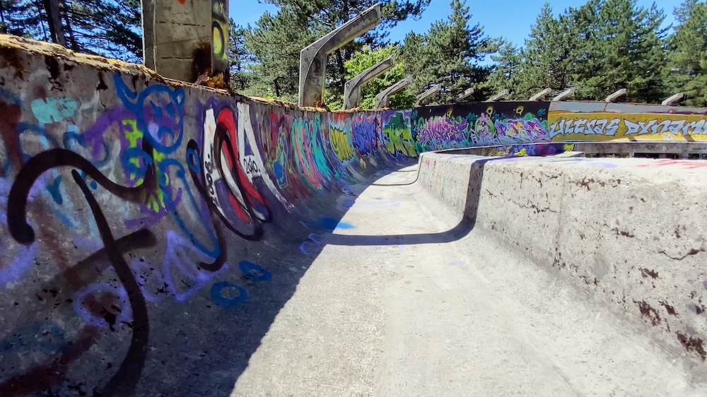 Blick in den ehemaligen Eiskanal der Bobbahn von Olympia'84, der heute zerfallen und mit Graffitti versehen ist.