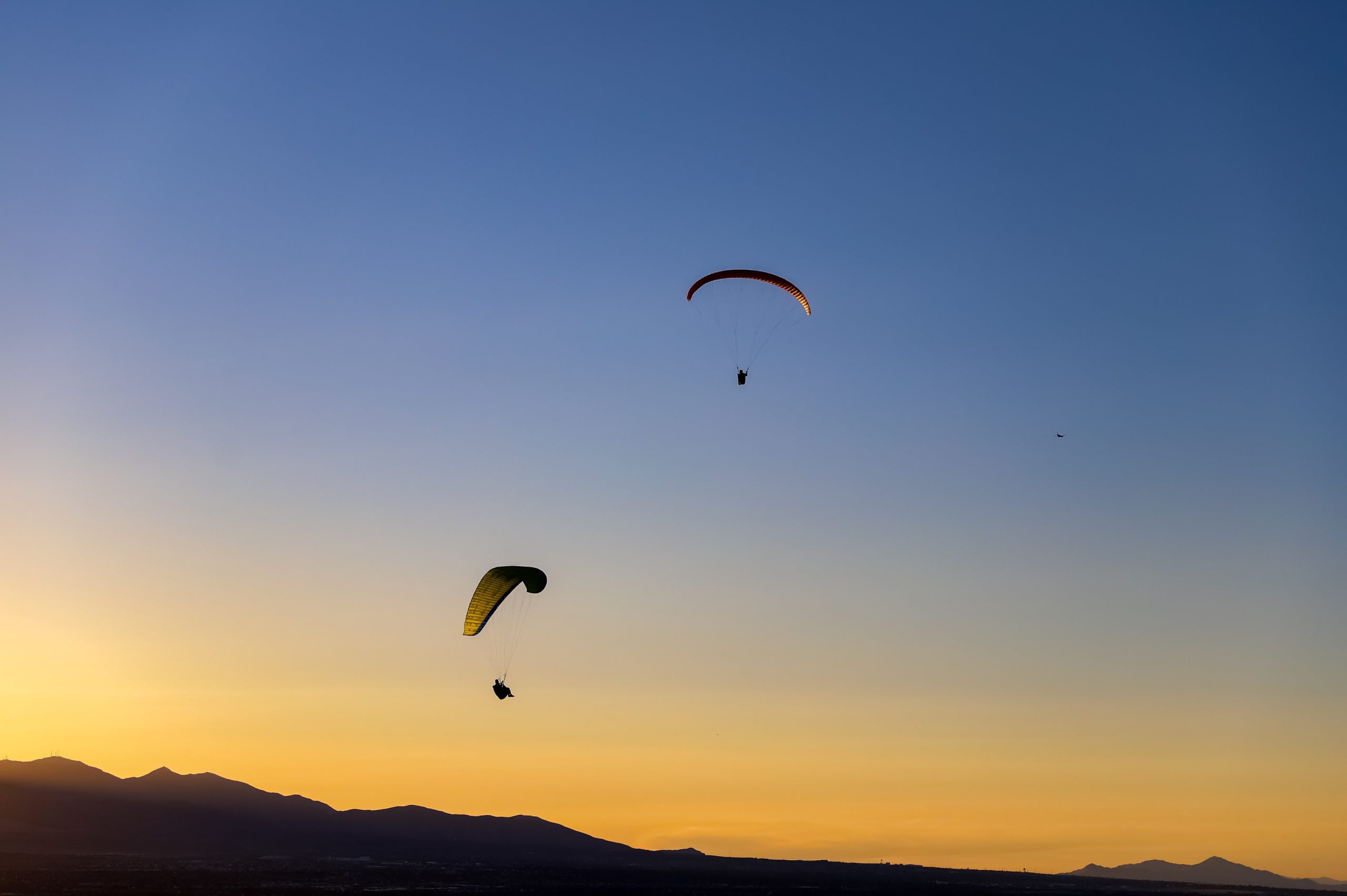 Paraglider fliegen durch den farbenfrohen Abendhimmel