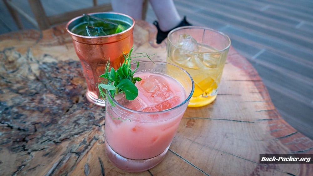 Drei Cocktails stehen auf einem Holztisch