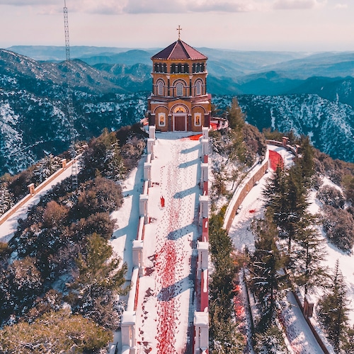 Drohnenaufnahme von einem Kloster in den schneebedeckten Trodoos Bergen in Zypern